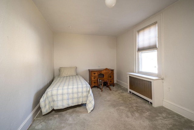 carpeted bedroom featuring radiator heating unit and baseboards