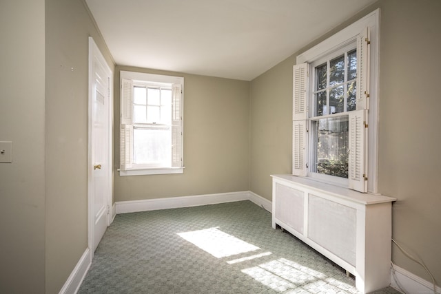 unfurnished room featuring plenty of natural light, baseboards, and carpet floors