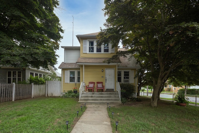 view of front of property with a front yard and fence