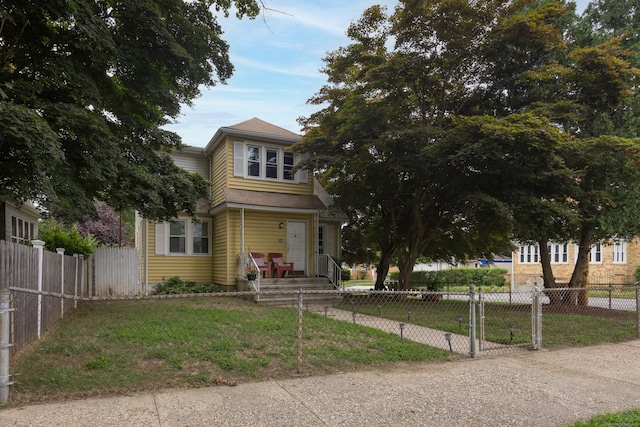 view of front facade featuring a fenced front yard, a front lawn, and a gate