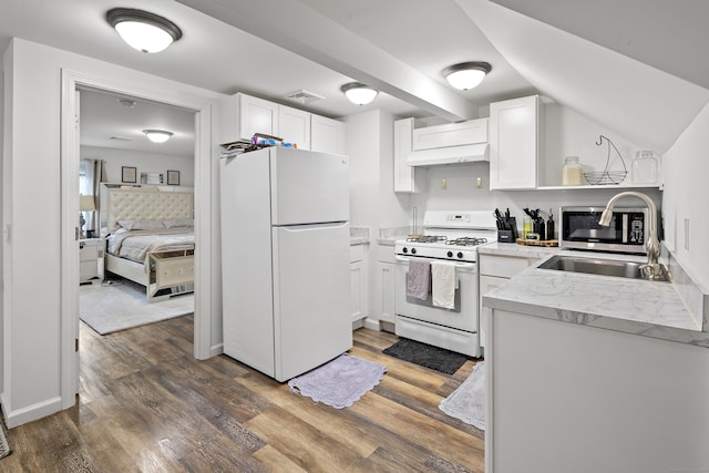 kitchen with white appliances, wood finished floors, visible vents, white cabinets, and exhaust hood