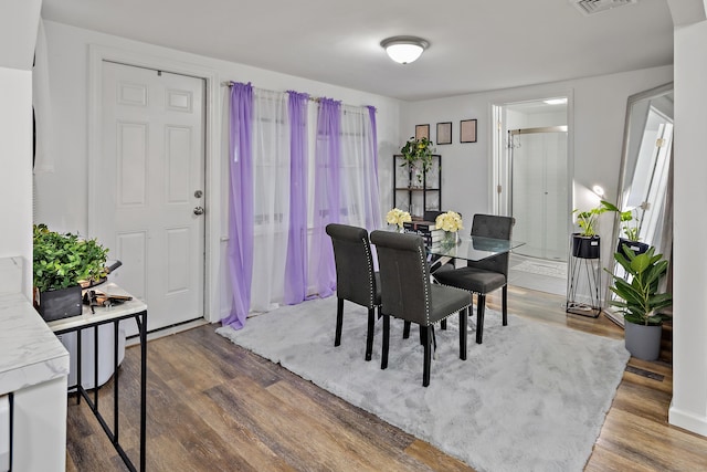 dining space with visible vents and wood finished floors