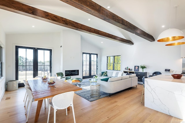 dining space featuring french doors, vaulted ceiling with beams, light wood-style floors, and visible vents