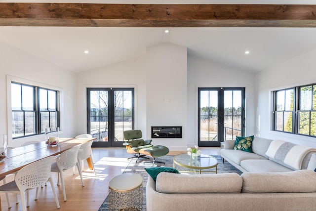 living area with vaulted ceiling with beams, recessed lighting, wood finished floors, and french doors