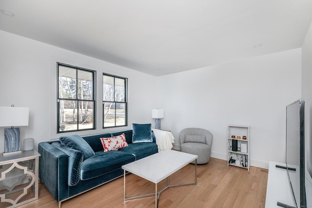 living area with baseboards and light wood-style flooring