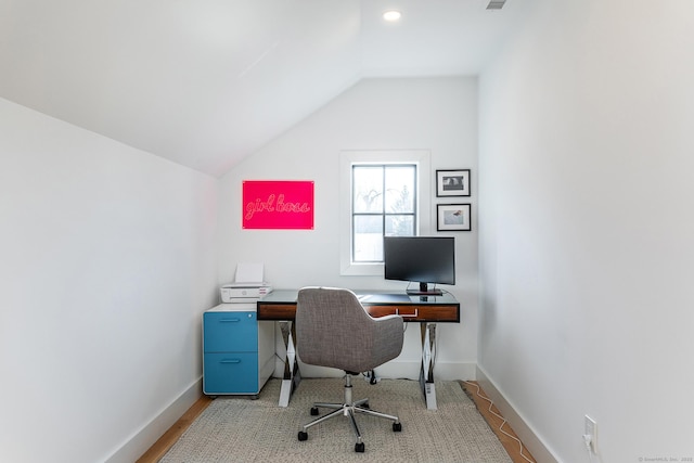 office space featuring baseboards, vaulted ceiling, and visible vents