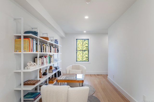 living area with recessed lighting, baseboards, and wood finished floors