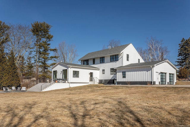 rear view of house featuring a lawn and board and batten siding