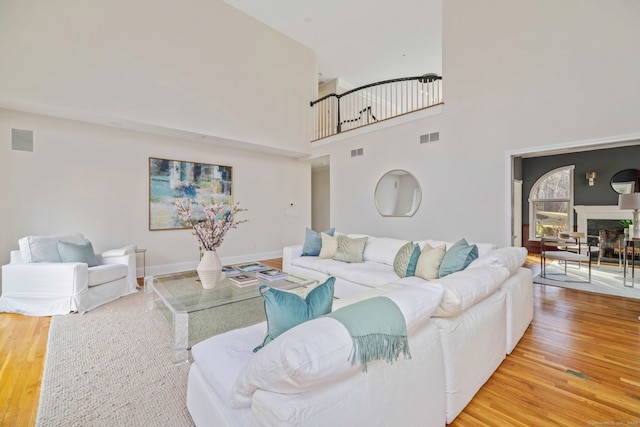 living room with wood finished floors, visible vents, and baseboards