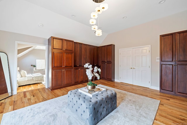 sitting room with baseboards, light wood-style flooring, and vaulted ceiling