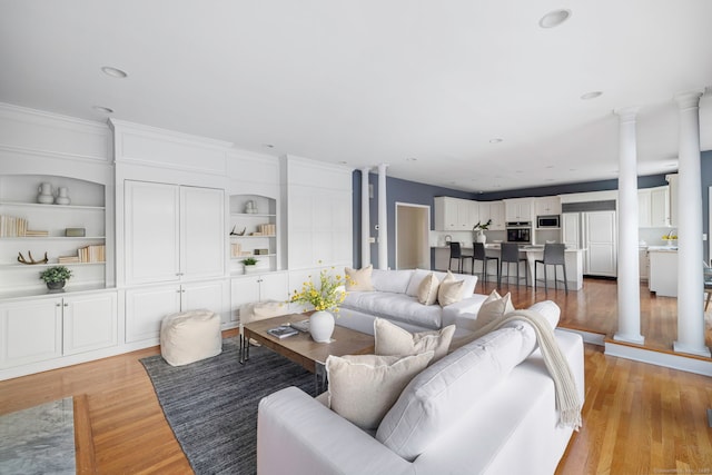 living room featuring built in features and light wood-type flooring