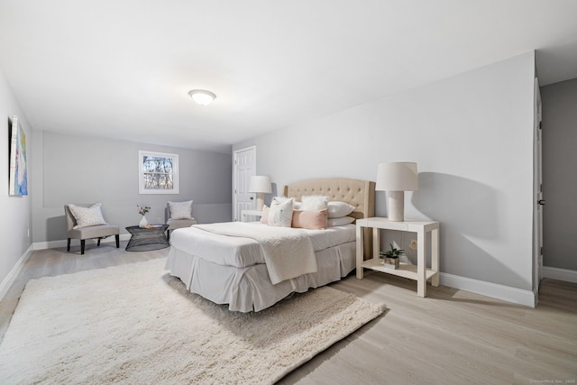 bedroom with baseboards and light wood finished floors