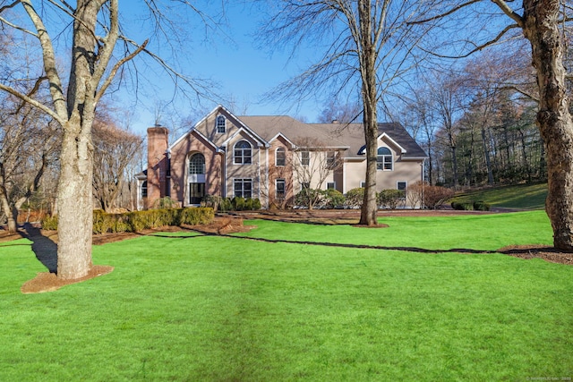 view of front of home with a chimney and a front lawn