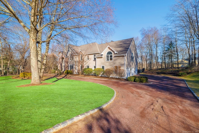 view of front facade with curved driveway and a front lawn