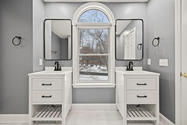 215 Paddock Hill Ln, Fairfield, CT 06824 - bathroom featuring marble look tile flooring, two vanities, and baseboards