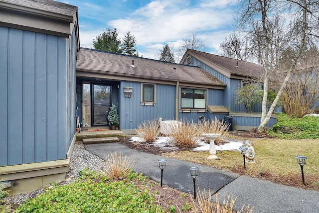 view of front facade featuring board and batten siding and roof with shingles