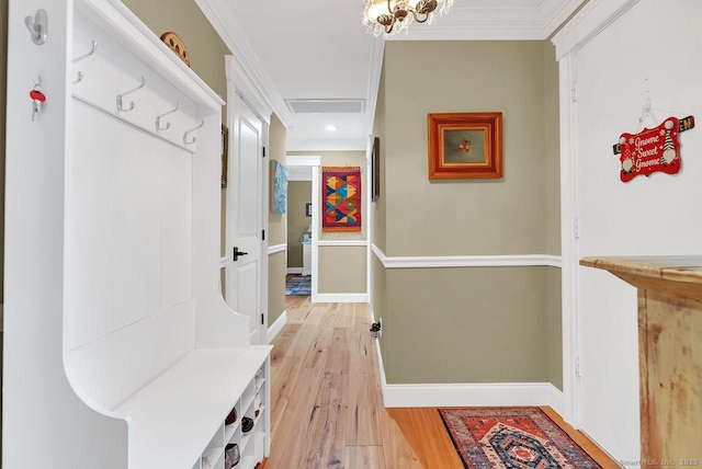 mudroom featuring light wood finished floors, visible vents, crown molding, and baseboards