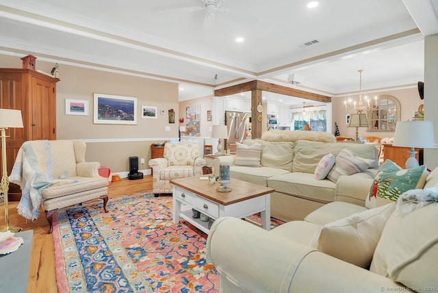 living room with light wood-type flooring, visible vents, ceiling fan with notable chandelier, recessed lighting, and crown molding