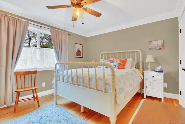 bedroom with crown molding, wood finished floors, and baseboards