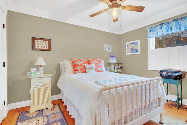 bedroom featuring a ceiling fan, crown molding, baseboards, and wood finished floors