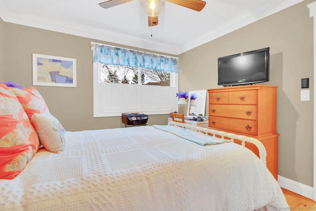 bedroom with a ceiling fan, wood finished floors, baseboards, and ornamental molding