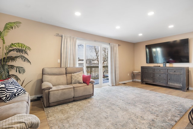 living area with recessed lighting, baseboards, and light wood finished floors