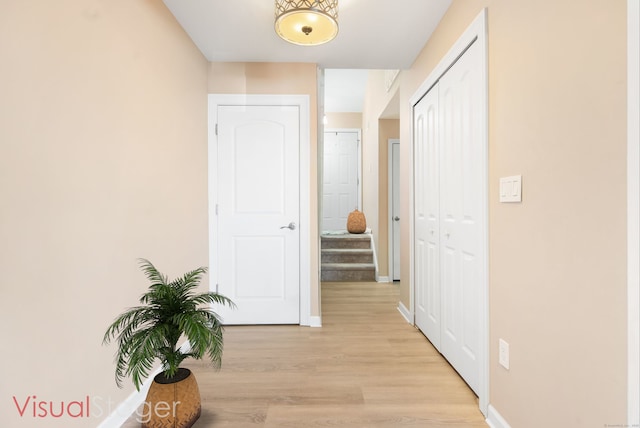 hall featuring baseboards and light wood-style flooring