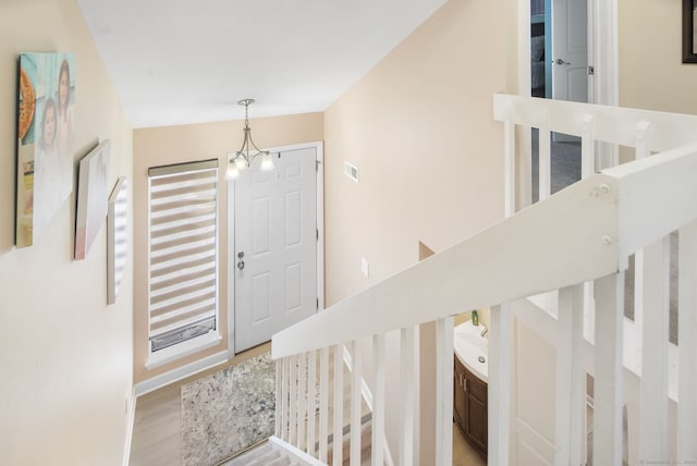 foyer entrance with a chandelier, visible vents, and light wood-style floors