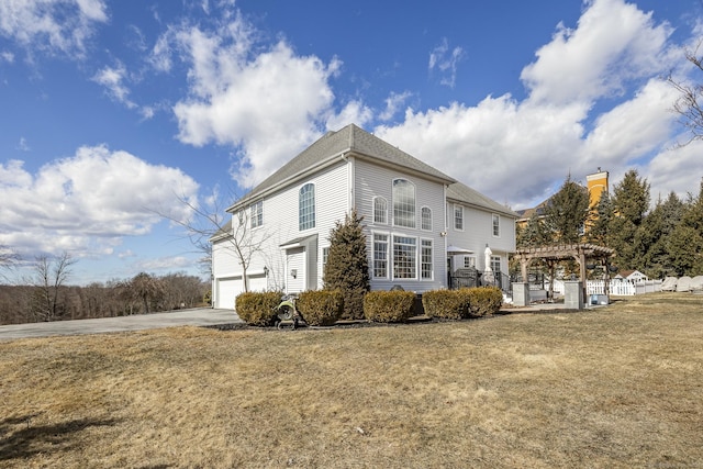 view of property exterior featuring a garage, a lawn, concrete driveway, and a pergola