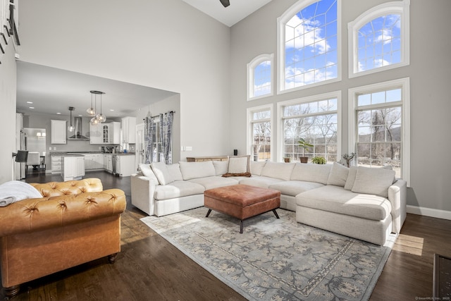 living room with baseboards, a high ceiling, and dark wood-style flooring