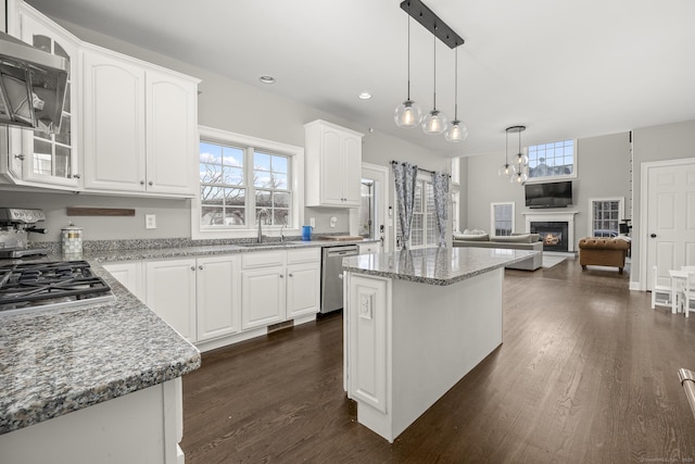 kitchen with white cabinetry, a sink, glass insert cabinets, appliances with stainless steel finishes, and a glass covered fireplace