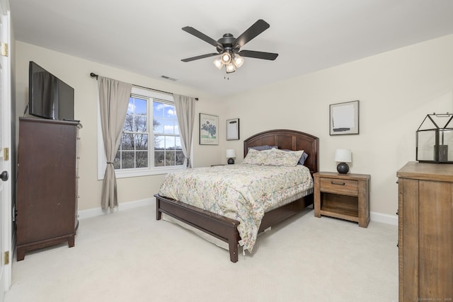 bedroom with ceiling fan, light colored carpet, visible vents, and baseboards