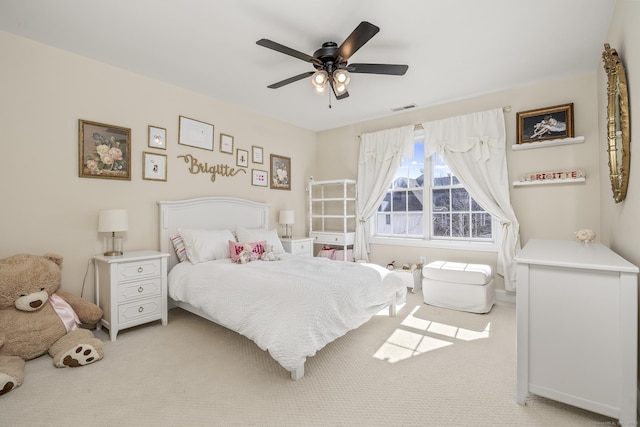 bedroom with visible vents, light colored carpet, and a ceiling fan