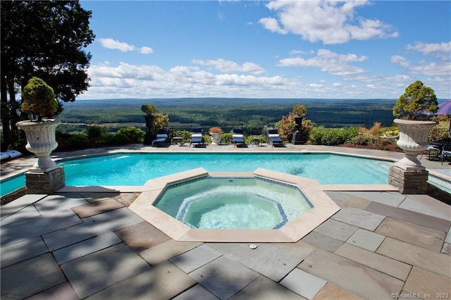 view of pool featuring a pool with connected hot tub and a patio area