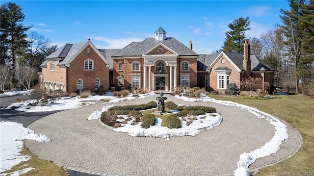 view of front facade with curved driveway and brick siding