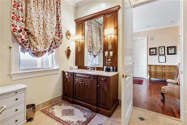 bathroom featuring wallpapered walls, vanity, baseboards, and ornamental molding