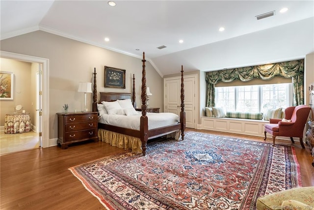 bedroom with visible vents, lofted ceiling, and wood finished floors