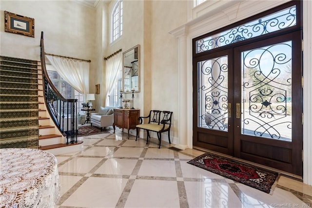 entrance foyer featuring stairs, plenty of natural light, french doors, and baseboards