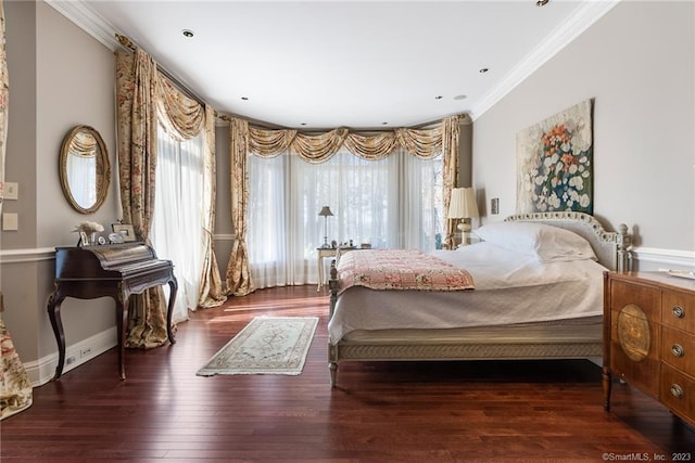 bedroom with multiple windows, wood finished floors, baseboards, and ornamental molding