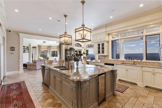 kitchen featuring a sink, open floor plan, dishwasher, and an island with sink