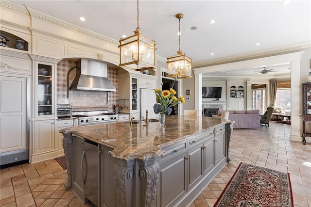 kitchen with ornamental molding, gray cabinets, a fireplace, wall chimney exhaust hood, and range