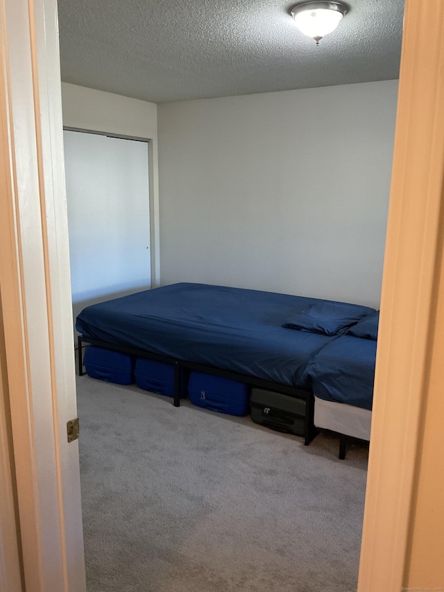 bedroom with carpet flooring and a textured ceiling