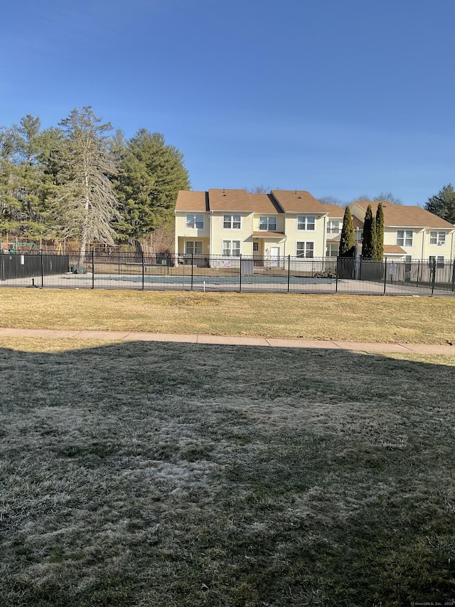 view of community with a residential view, a lawn, and fence