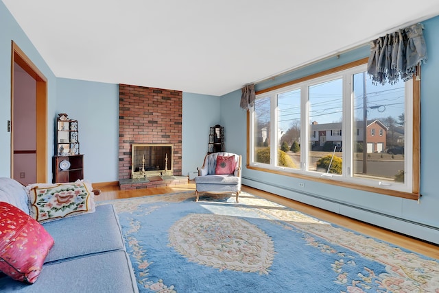 living room featuring a baseboard radiator, baseboard heating, wood finished floors, and a fireplace