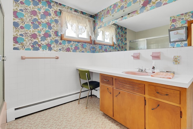 full bath with a shower with shower door, a wainscoted wall, wallpapered walls, baseboard heating, and vanity