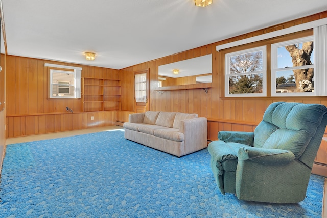 carpeted living room featuring wooden walls and cooling unit