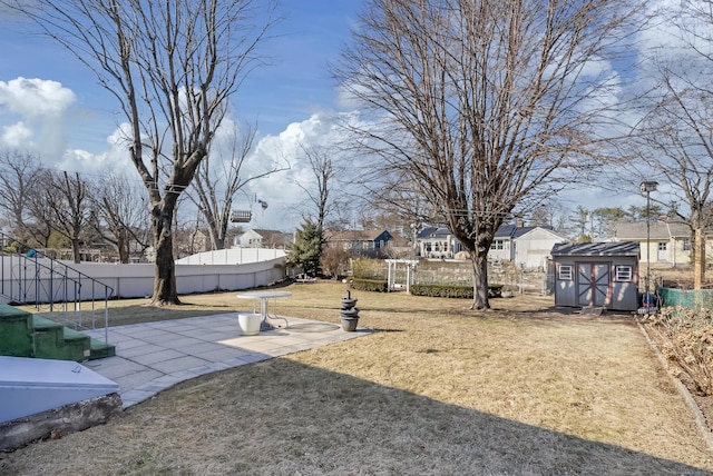 view of yard featuring a patio, a fenced backyard, a shed, a residential view, and an outdoor structure