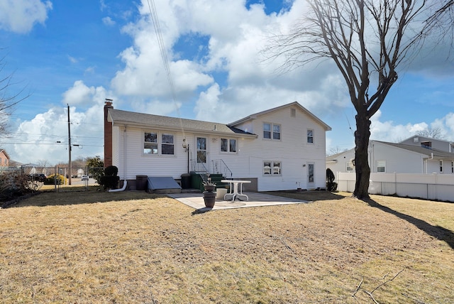 rear view of house with a patio, a lawn, fence private yard, and a chimney