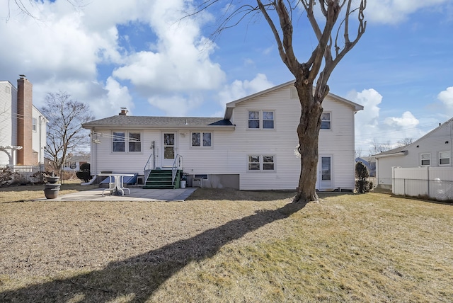 back of house with fence, a chimney, a lawn, and a patio area