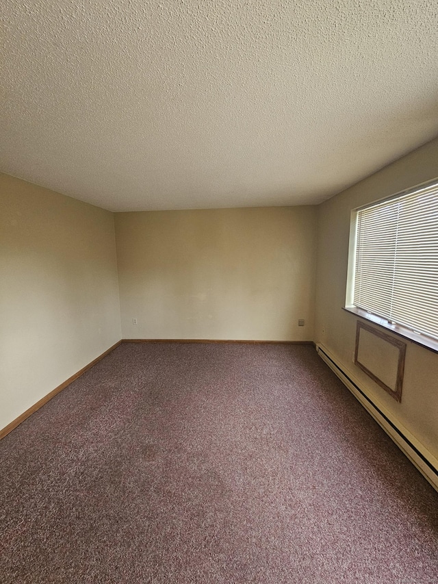 carpeted spare room featuring a textured ceiling, baseboards, and a baseboard radiator